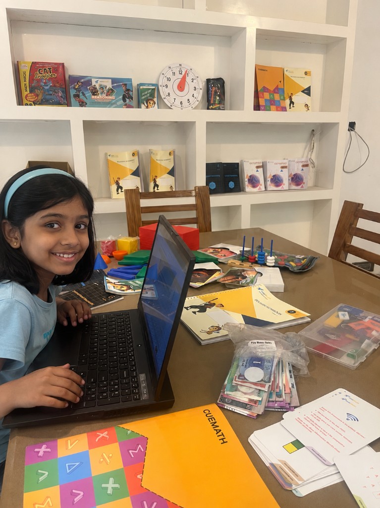 A student smiling while learning with Cuemath materials